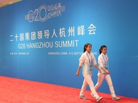 志愿者经过G20杭州峰会背景板