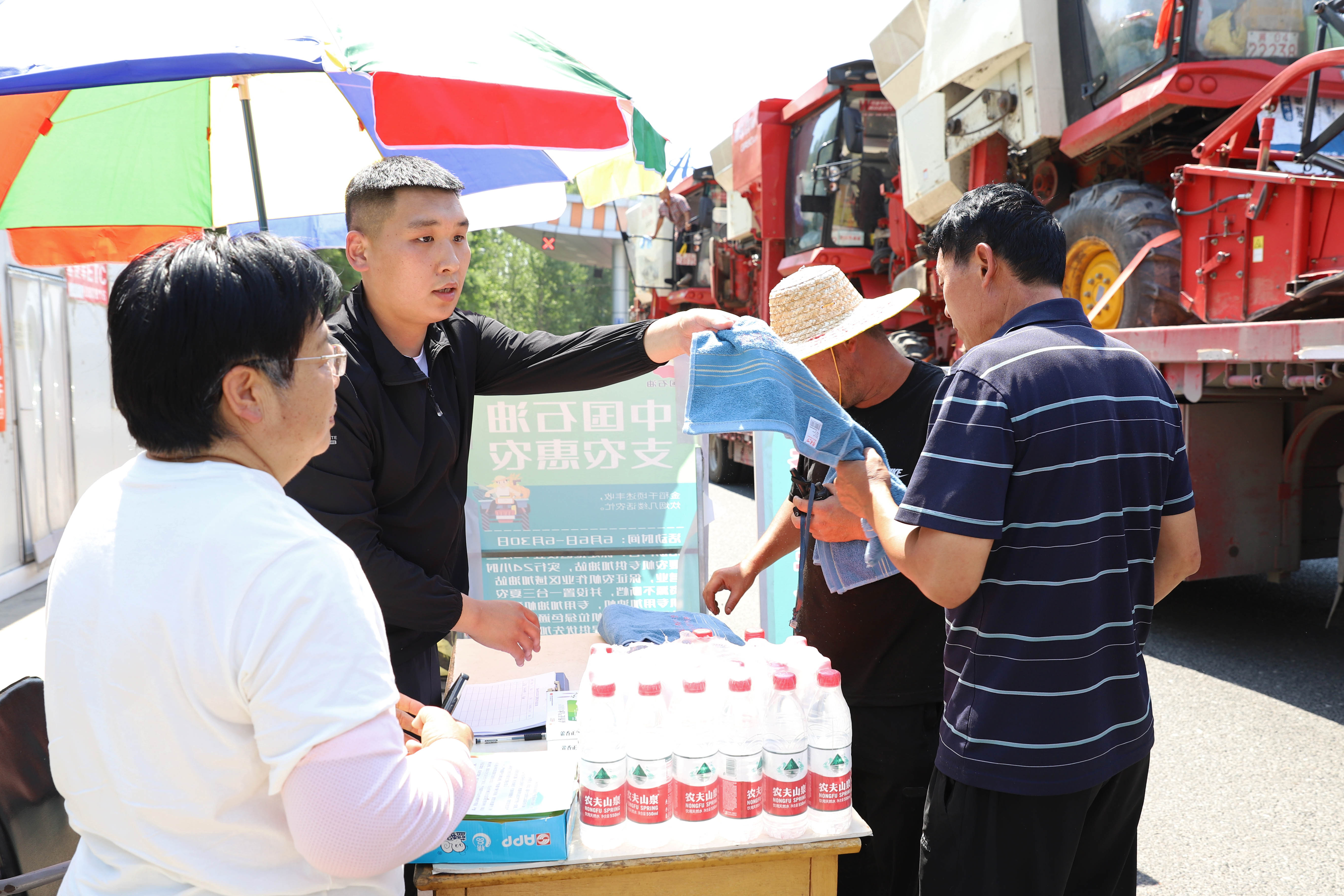 （原创）河北涿州：做好农机跨区作业服务工作 护航“三夏”麦收_fororder_6月14日上午，河北涿州服务站工作人员为跨区作业农机手发放毛巾。熊华明摄