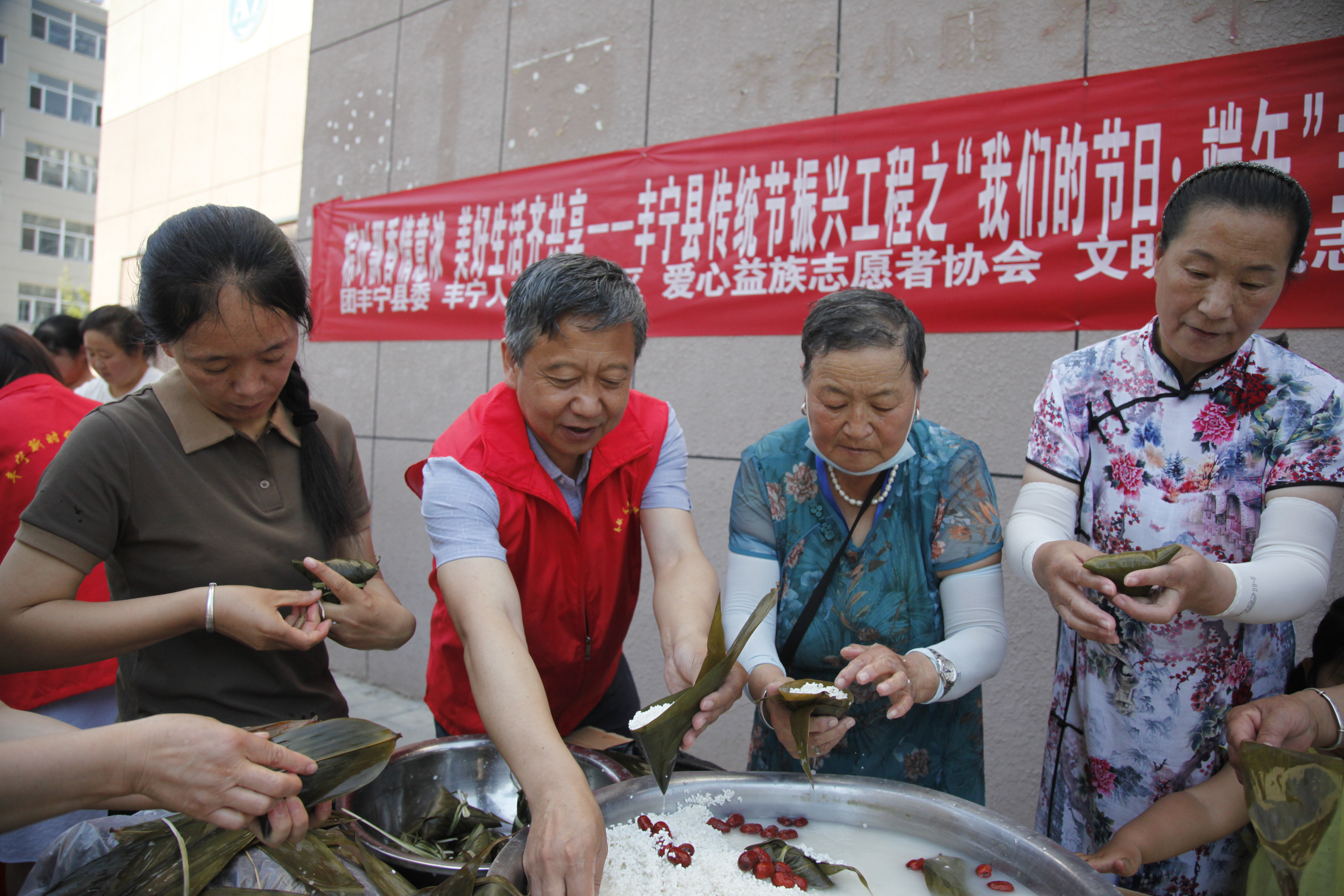 图片默认标题_fororder_志愿者和群众认真在包粽子 李佳园摄.JPG
