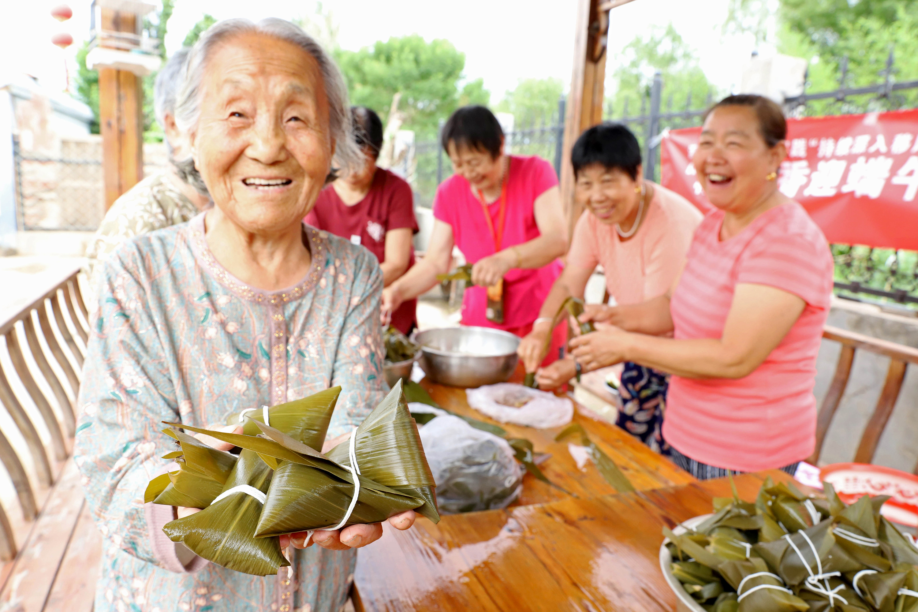 图片默认标题_fororder_老人高兴地展示自己包的粽子。熊华明摄