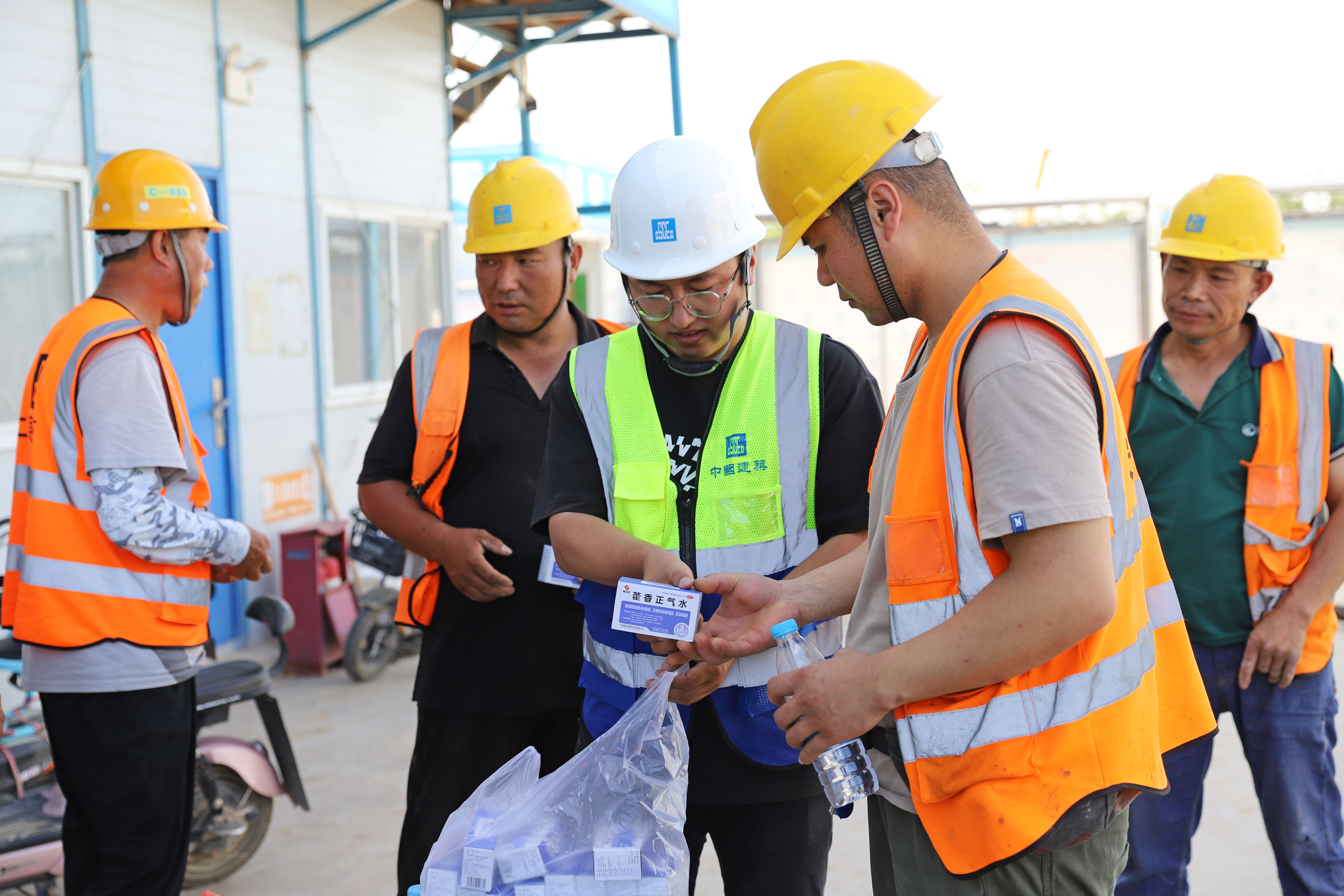 河北涿州：多举措应对高温 项目建设提速提质_fororder_6月29日，河北省涿州市松林店经济开发区基础设施暨云制造小镇PPP项目建设现场，项目建设方为工人发放藿香正气水等消暑物品。