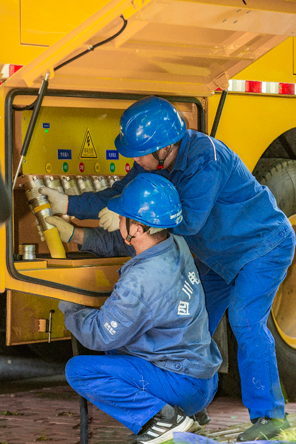 四川：成都大运会供电进入赛时保障阶段_fororder_7月18日，国家电网成都大运会电力保障队队员在现场检查和测试应急发电车的接入功能供图-安伟[1]