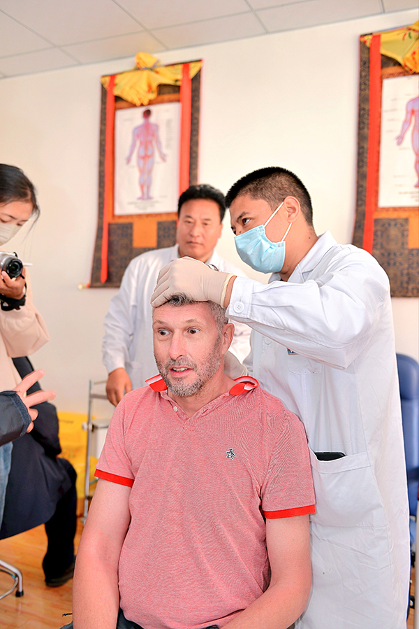 海外“網紅”點讚藏醫藥文化：這真是太神奇了！_fororder_李·巴雷特體驗針灸療法-攝影-徐軍