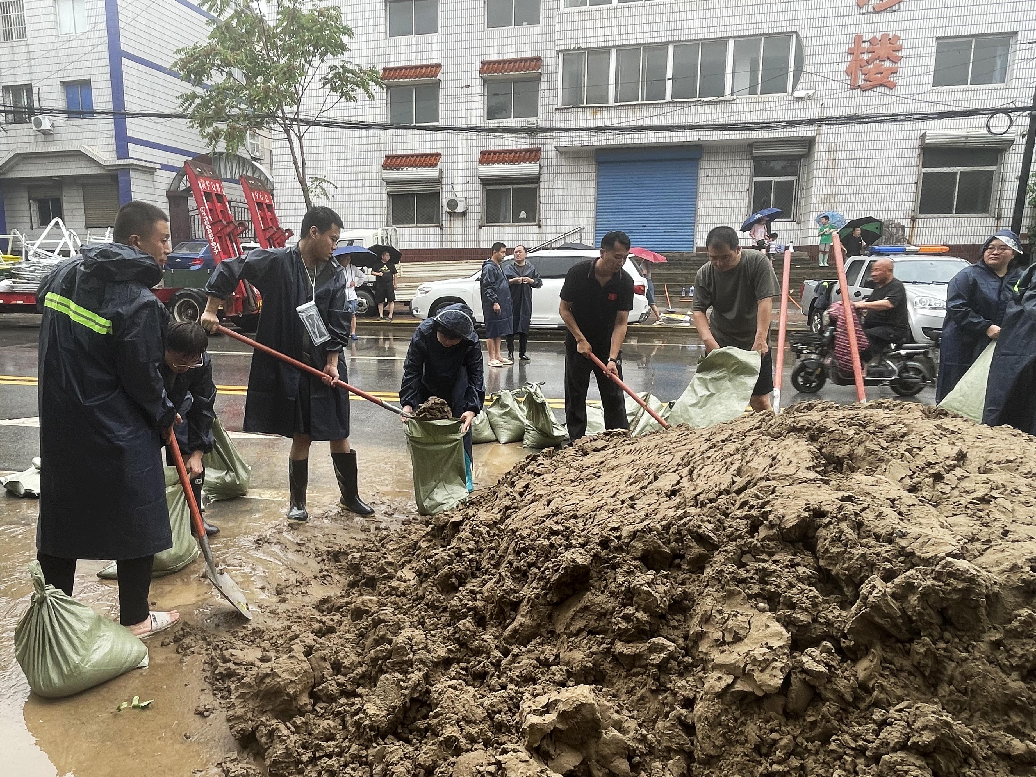 河北涿州：3万余名党员防汛一线筑起“红色堤坝”_fororder_7月31日，涿州市清凉寺街道工作人员和所属各村、社区抢险队党员在甲秀路上填装防洪沙袋。熊华明摄