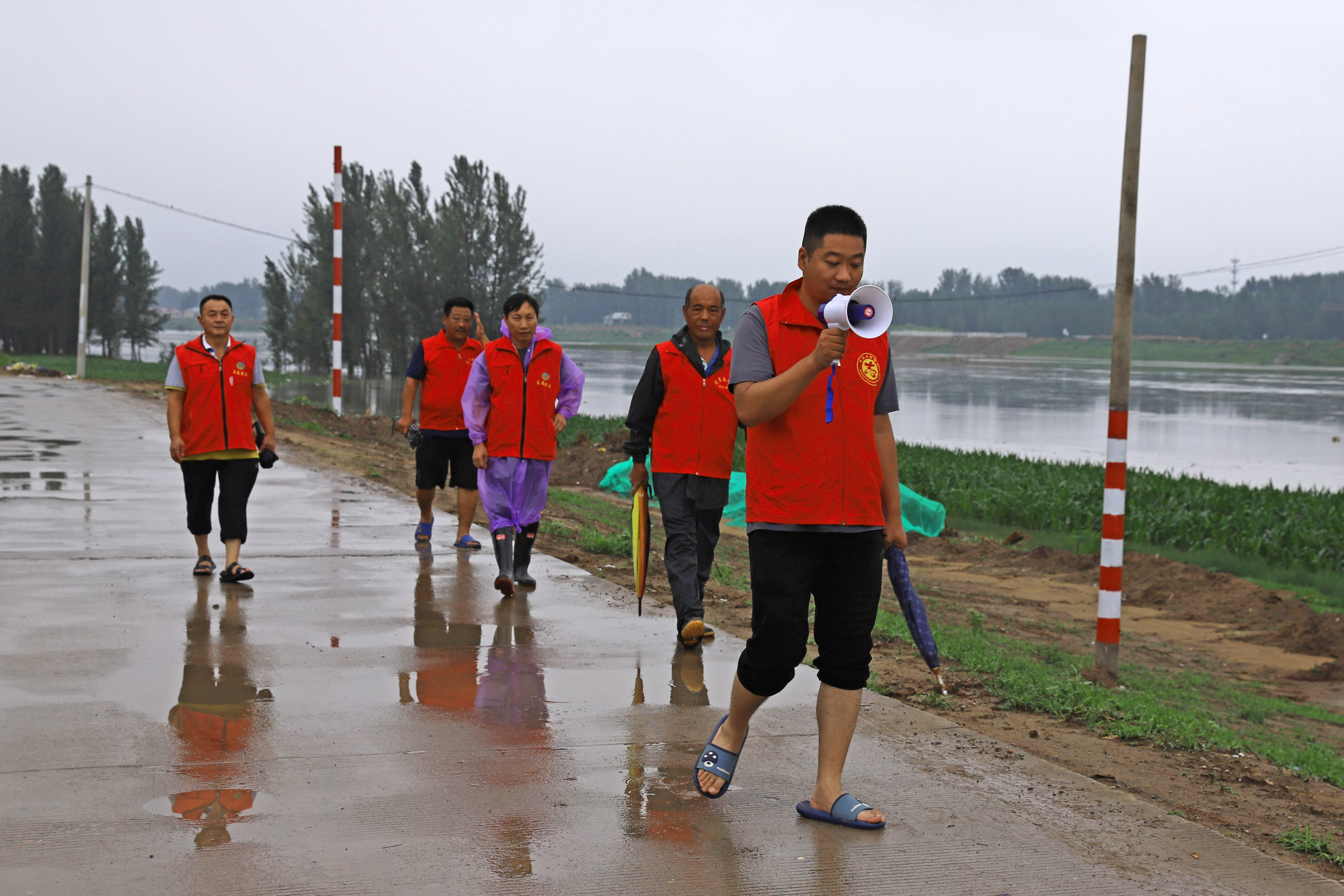 河北涿州：3万余名党员防汛一线筑起“红色堤坝”_fororder_7月31日，涿州市刁窝镇西茨村工作人员在白沟河大堤上巡查。熊华明摄