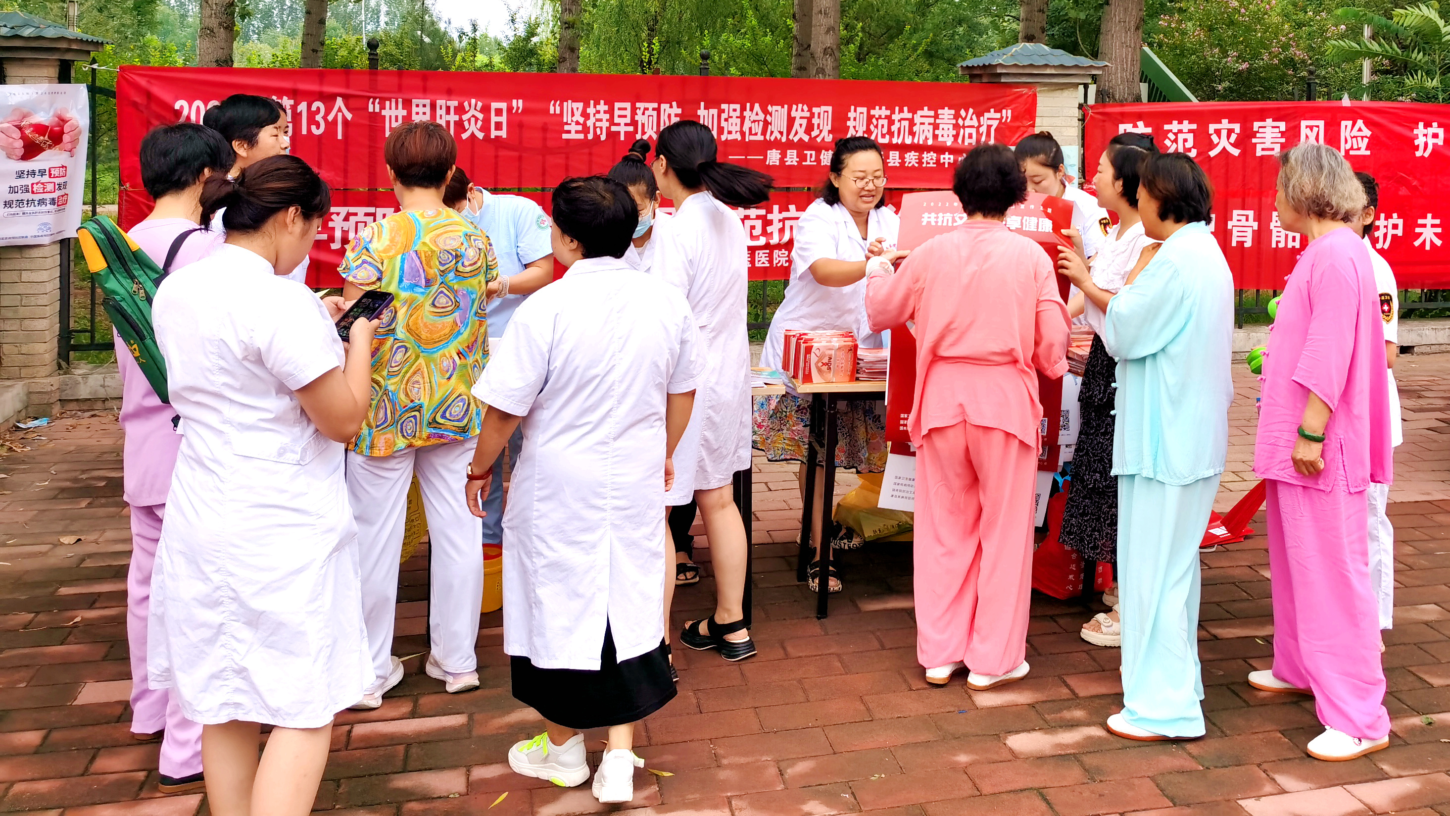 （原创）河北唐县：组织开展“世界肝炎日”健康科普宣传活动_fororder_工作人员向群众发放宣传资料并讲解肝炎相关知识