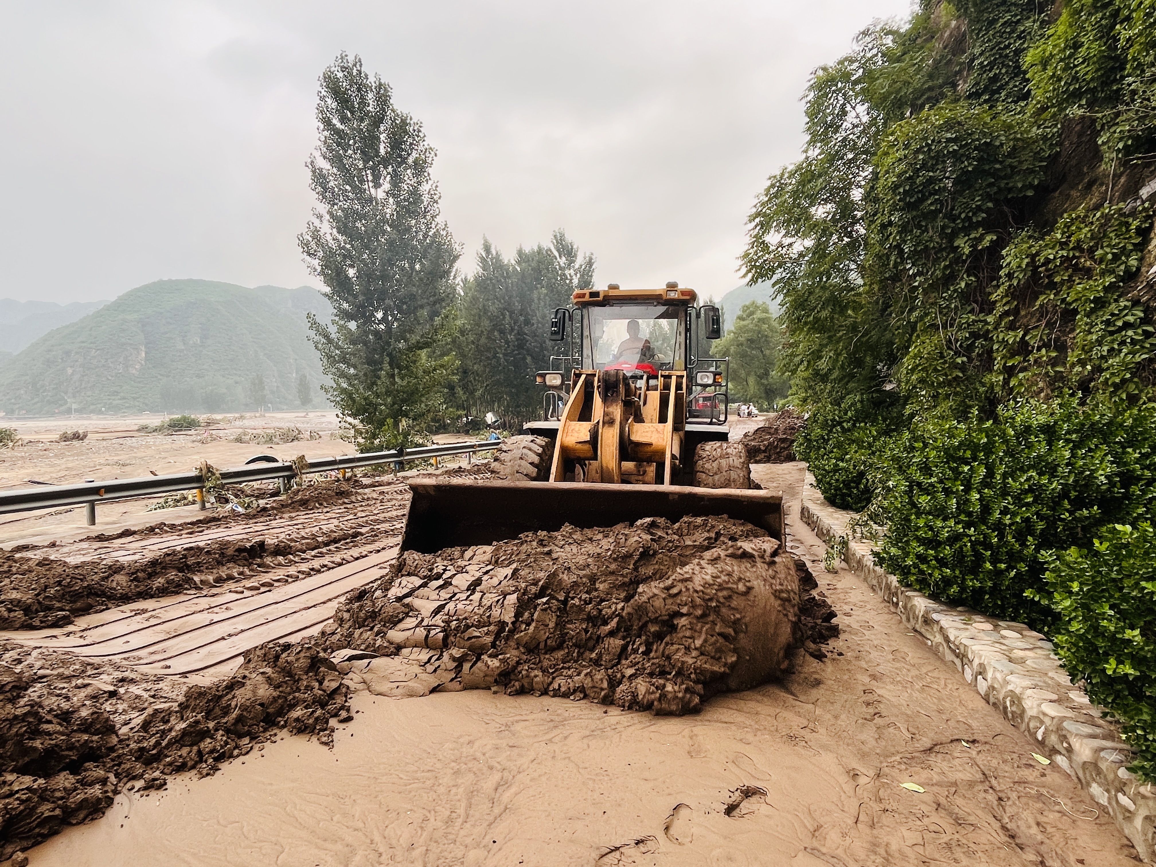 （原创）河北涞水：野三坡景区时隔11年再遭重创_fororder_图为救援人员正在涞水县野三坡大道开展沿河道路清淤作业。（李金璐 摄）.JPG