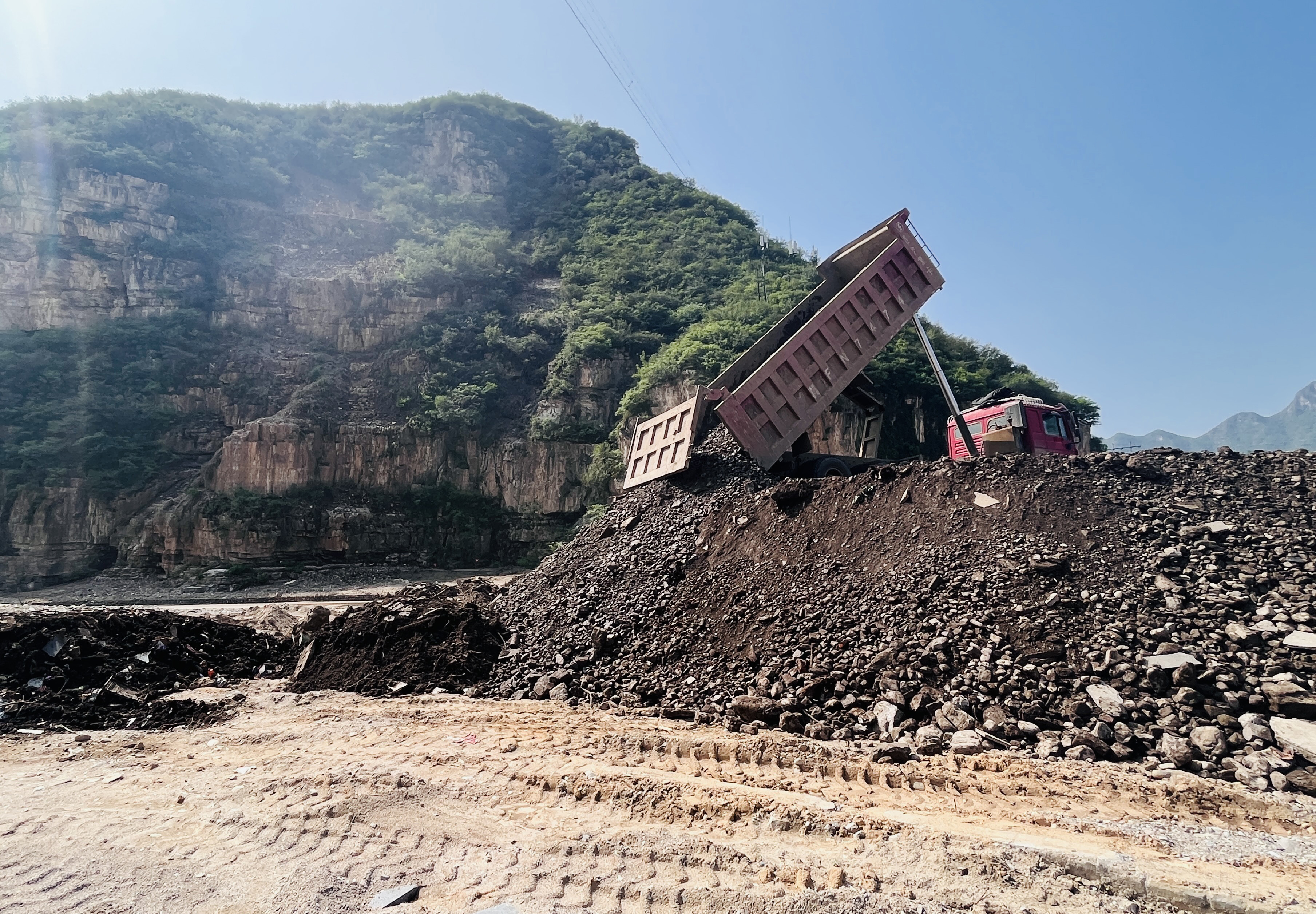 河北涞水：做好灾区垃圾清运 保障民众生产生活_fororder_图为在涞水县三坡镇苟各庄村，工程车正在倾卸淤泥垃圾。（李金璐 摄）.JPG