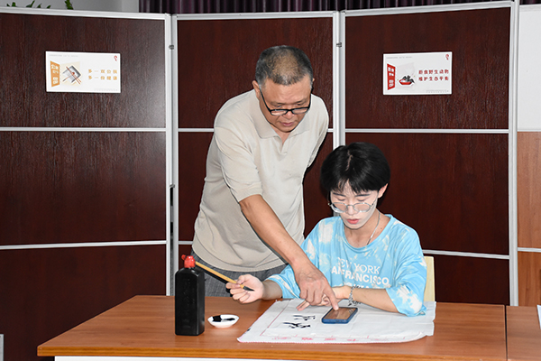 文化传承 强国有我 自贡市积极备战全省第二届青少年书画传习大会_fororder_1郭昤（左）给学生进行指导（摄影-赵丽）