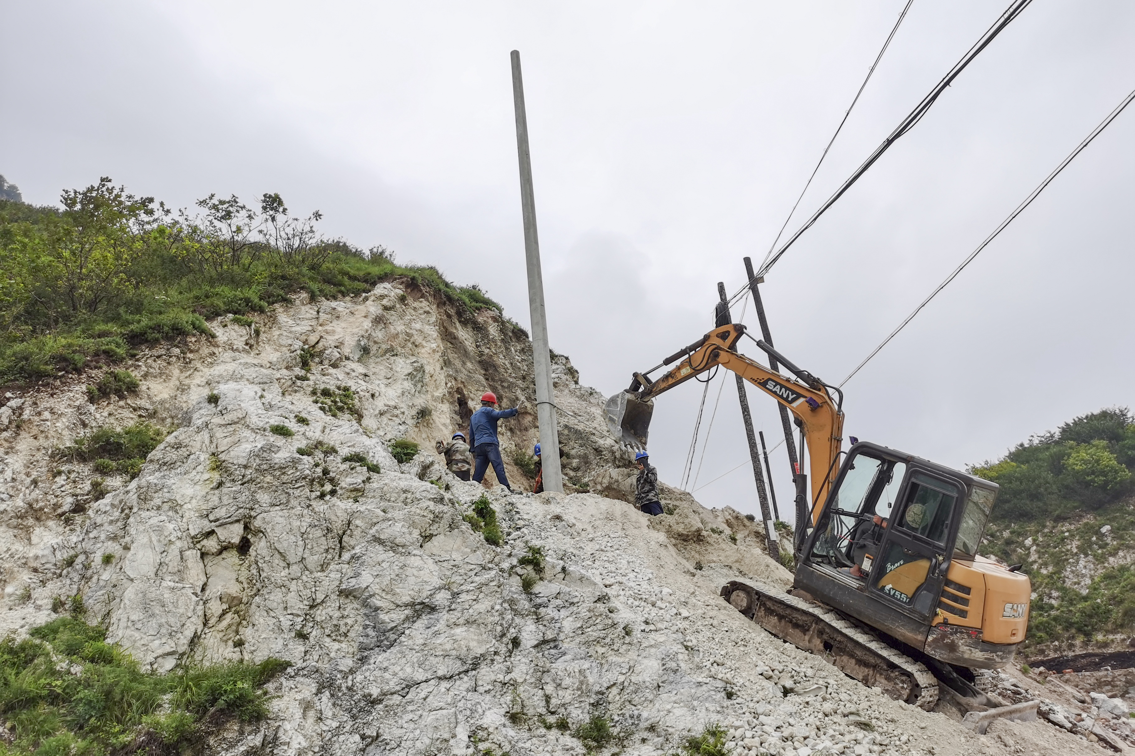跨越黄安岭——涞源的电点亮涞水的灯_fororder_8月7日，国网涞源县供电公司抢修队在涞源涞水跨区供电施工现场组立电杆。马新亮 摄