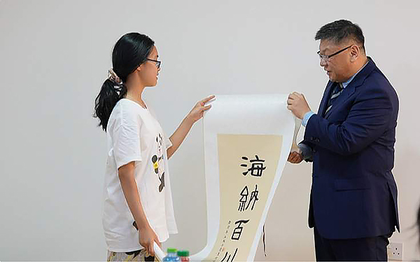 “熊猫小记者”到访驻卡塔尔使馆 圆梦“外交官”_fororder_熊猫小记者王子墨送上书法作品“海纳百川”-供图-成都市广播电视台