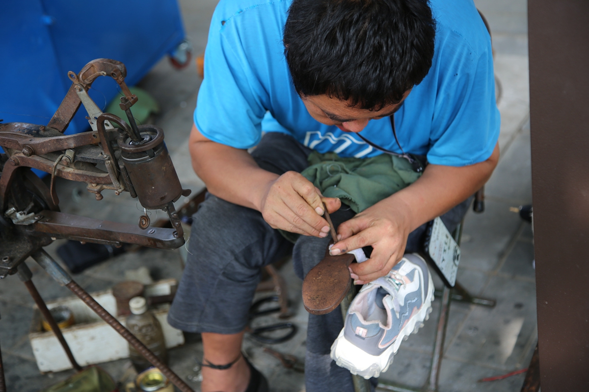 保定市满城区：打造城区“温馨港湾”_fororder_满城区城市港湾下的残疾人士修补鞋子 摄影 宋王晗