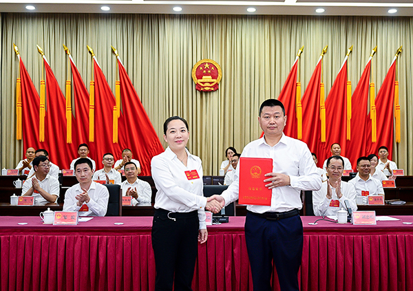 (左一)向新当选的区人民政府区长刘杰颁发当选证书(摄影