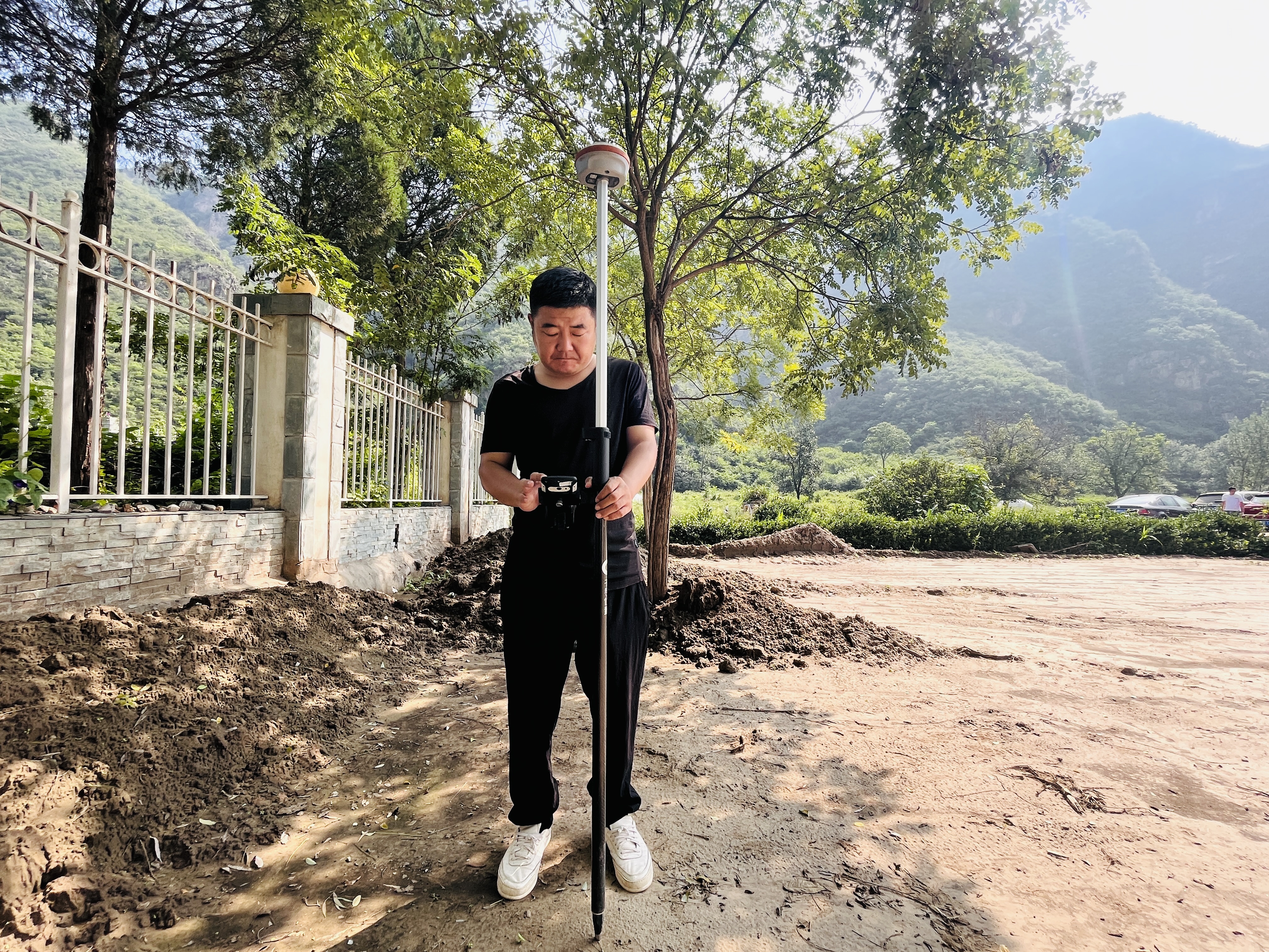 河北涞水：做好灾区垃圾清运 保障民众生产生活_fororder_图为在涞水县三坡镇紫石口村，生态环境局工作人员正在进行垃圾中转站重建点位测绘。（李金璐 摄）.JPG