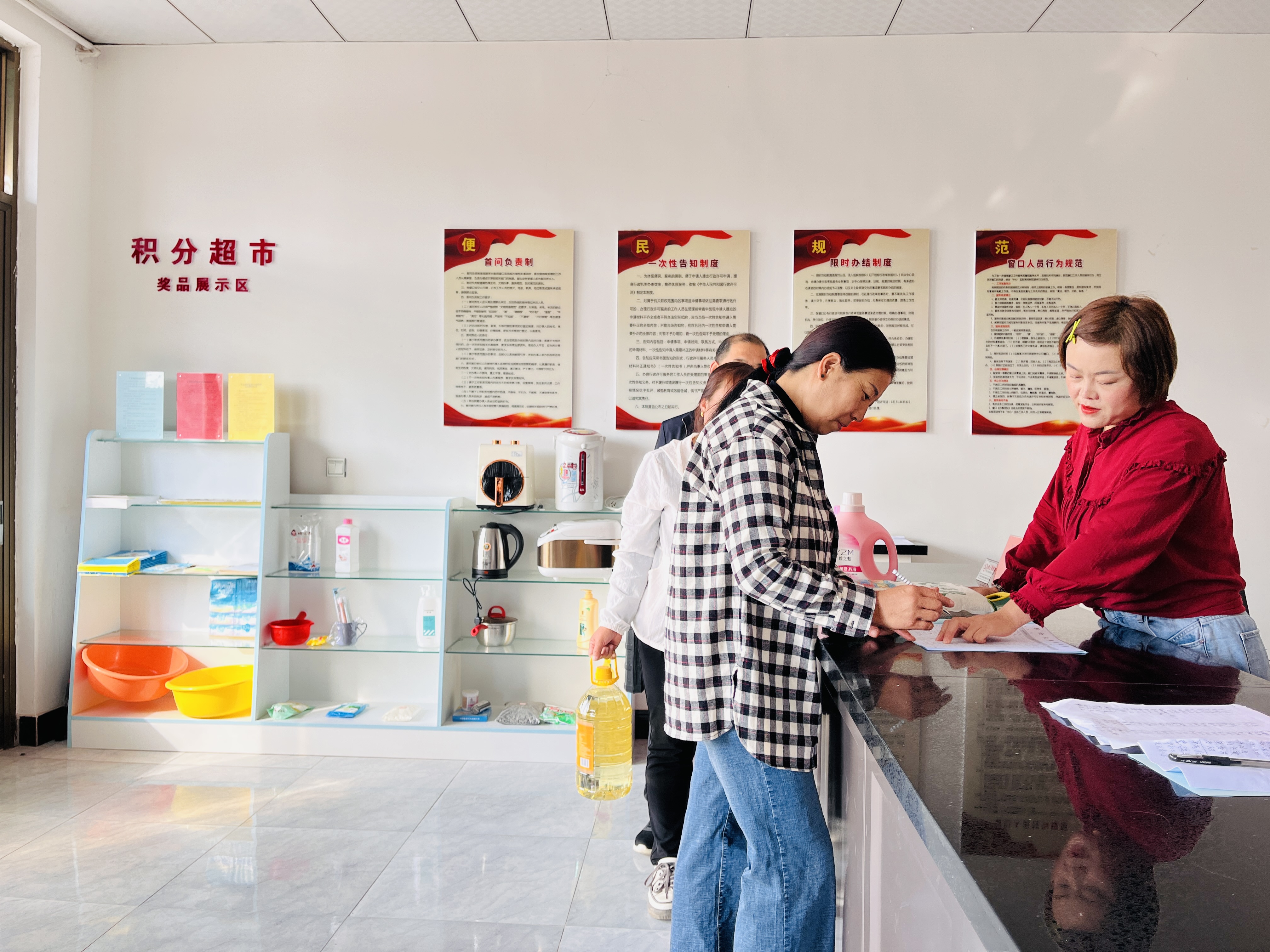 图片默认标题_fororder_图为在涞水县义安镇南高洛村积分超市内，党员志愿者和网格员用积分兑换物品。（李金璐 摄）.JPG