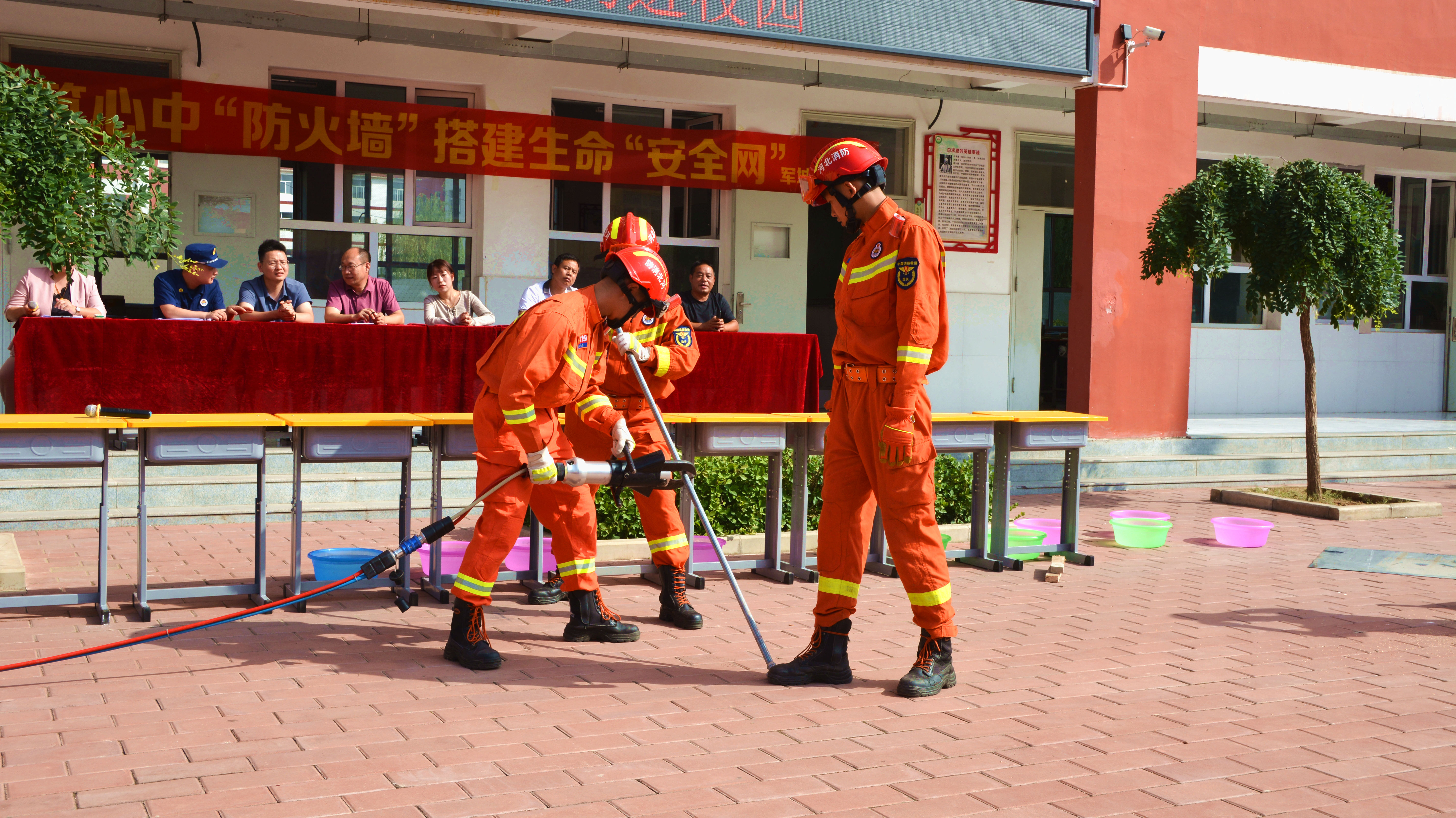 （原创）河北唐县：共筑心中防火墙 搭建生命安全网_fororder_消防员正向学生们演示破拆工具如何使用 (3).JPG