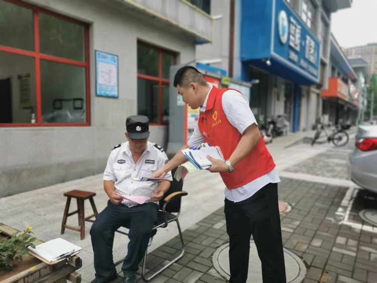 圖片默認標題_fororder_滿城區政務服務中心工作人員向社區人員發放宣傳資料 攝影 張麗娜