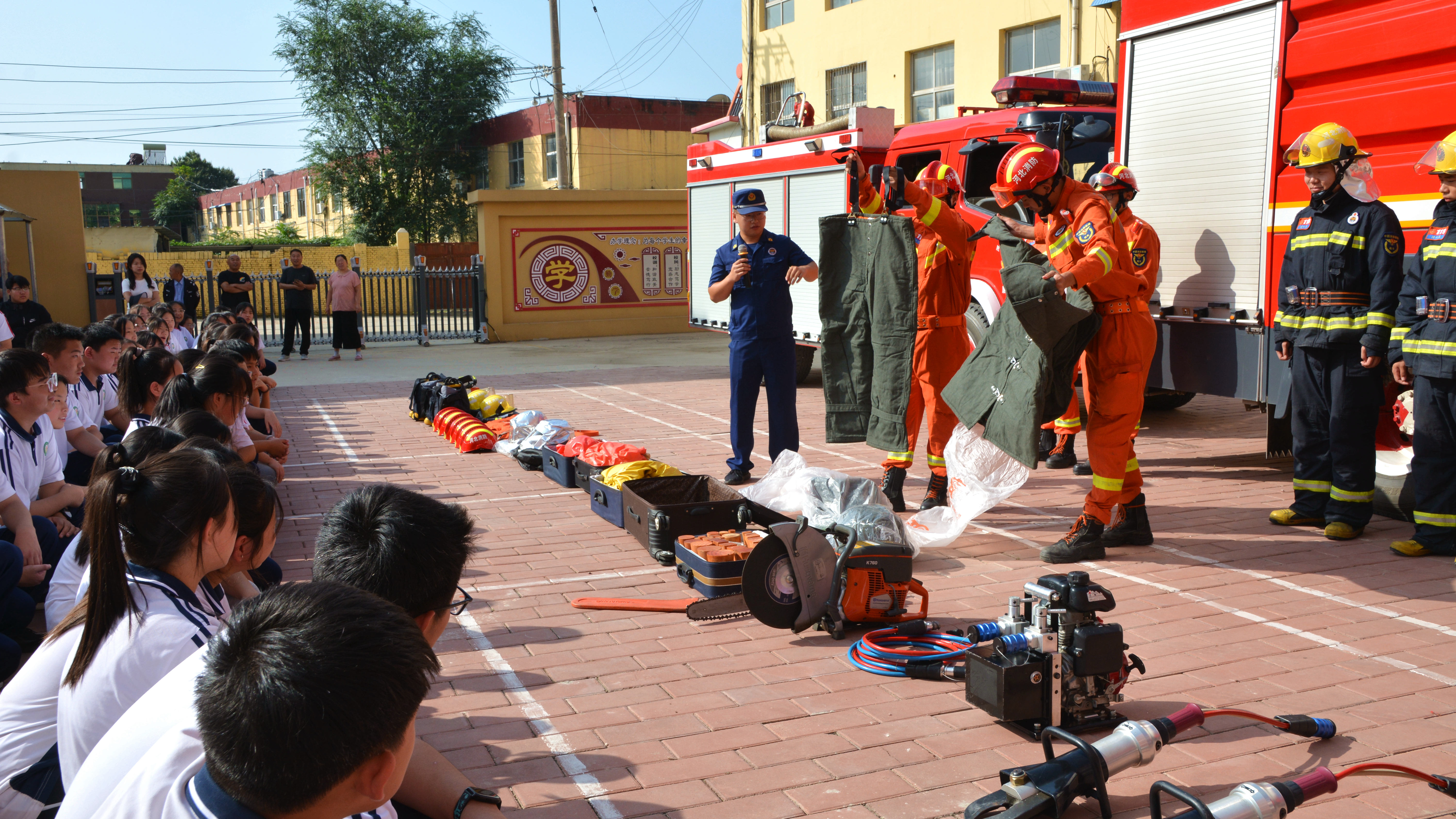 （原创）河北唐县：共筑心中防火墙 搭建生命安全网_fororder_宣传员正向学生们讲解消防车、破拆工具、防火服等的构造和工作原理.JPG