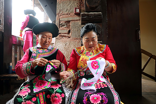 中國古羌城獨具特色的人文旅遊“火”起來_fororder_兩名羌族婦女展演羌繡技藝-供圖-中新社