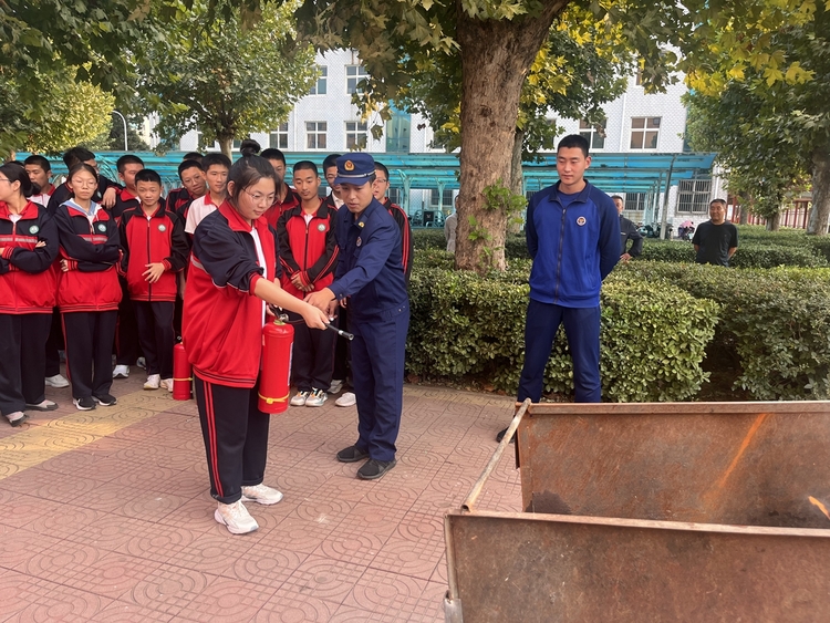 图片默认标题_fororder_满城区消防大队工作人员指导学生使用灭火器 摄影 李英
