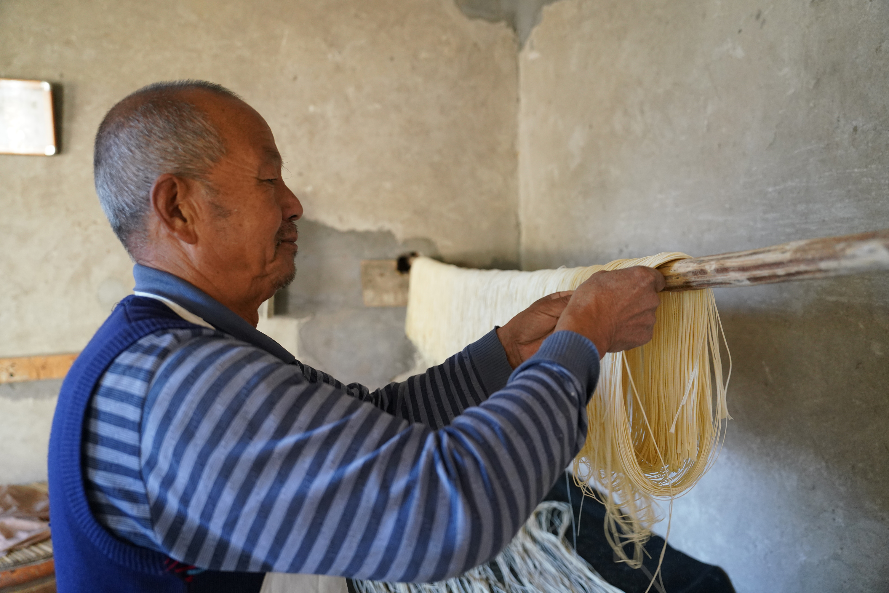 圖片默認標題_fororder_李明雙將抻面上擔準備晾曬。攝影 王磊