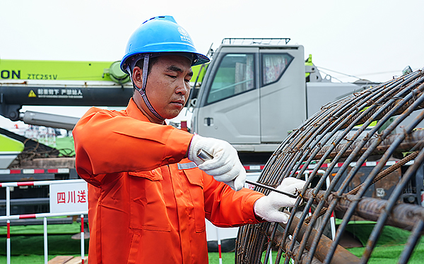 哈密送重庆±800千伏特高压直流输电线路工程四川段进入全面建设阶段_fororder_电力工人在哈密～重庆±800千伏特高压直流输电线路工程（川3标）N6205号塔位加固绑扎钢筋笼（谭谢阳-摄）