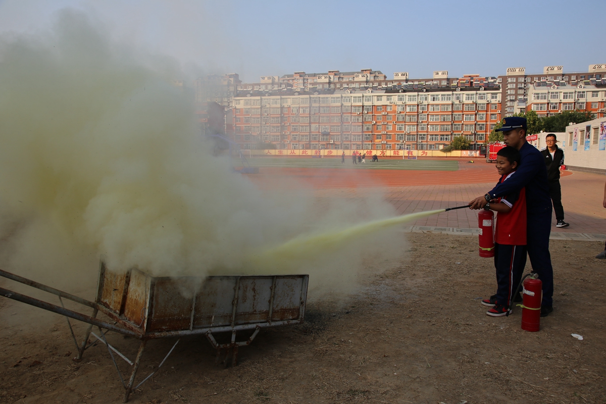 图片默认标题_fororder_消防队员与学生共同模拟救火 摄影 袁野.JPG