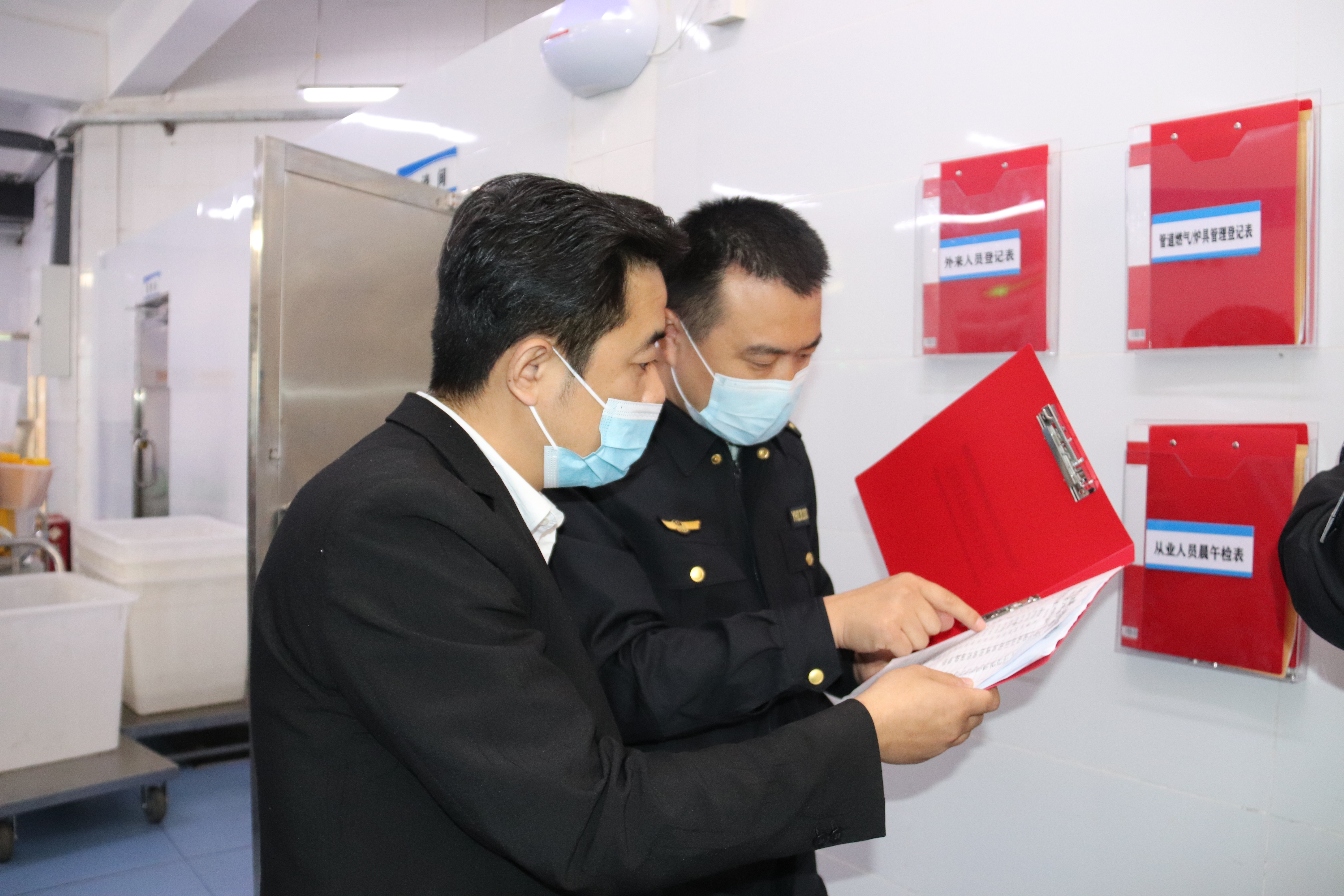 开启智慧食安监管平台 校园食堂迎新模式 裕华区市场监督管理局 助力全市首家“校园智慧餐厅”建设落地_fororder_裕华区市场监督管理局监管人员查看食堂工作台账.JPG