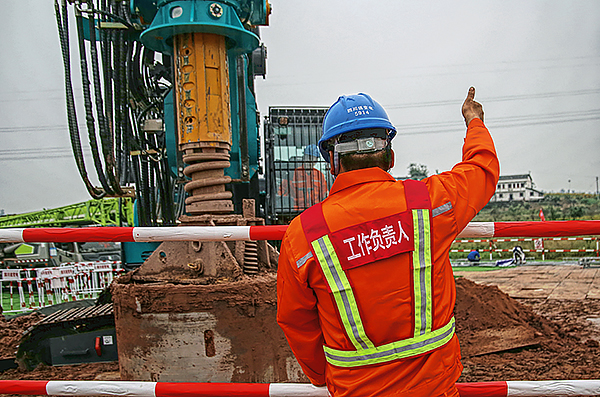 哈密送重庆±800千伏特高压直流输电线路工程四川段进入全面建设阶段_fororder_电力工人在哈密～重庆±800千伏特高压直流输电线路工程（川3标）N6205号塔位指挥旋挖机开挖基础（谭谢阳-摄）