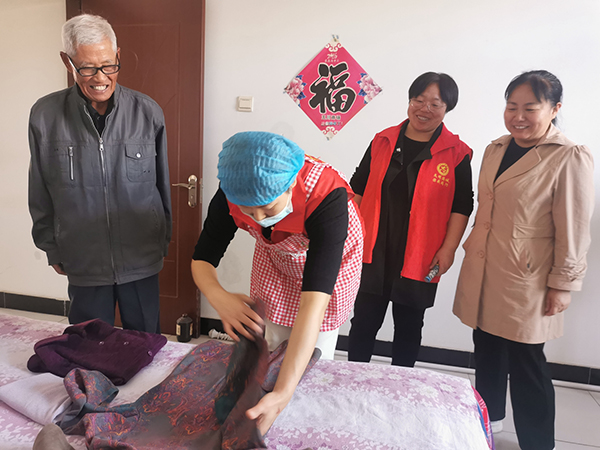 保定市满城区：浓情重阳敬老行 福嫂敲门暖人心_fororder_满城区福嫂为行动不便的老人收纳衣物 摄影 贾俊杰