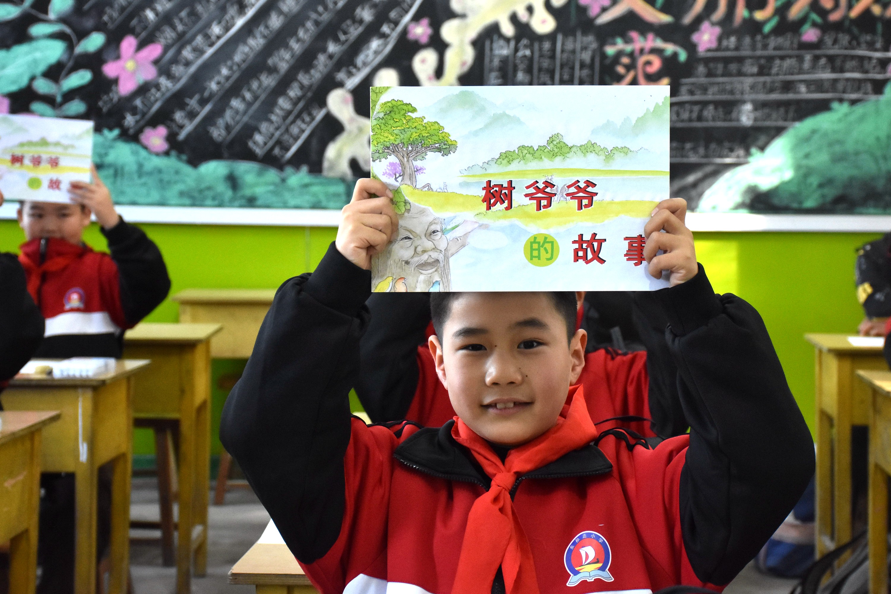 河北清苑：環保宣傳進校園 文明理念入童心_fororder_同學們展示環保主題繪本。 趙琪攝.JPG