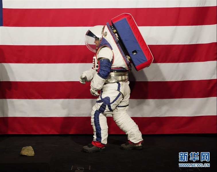 10月15日，在美国华盛顿美航天局总部，一名身穿新一代宇航服的工程师演示行走动作。新华社记者 刘杰 摄