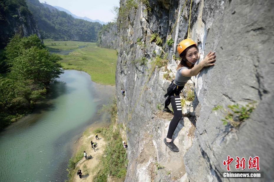 美女挑战百米崖壁攀岩 轻松微笑玩自拍
