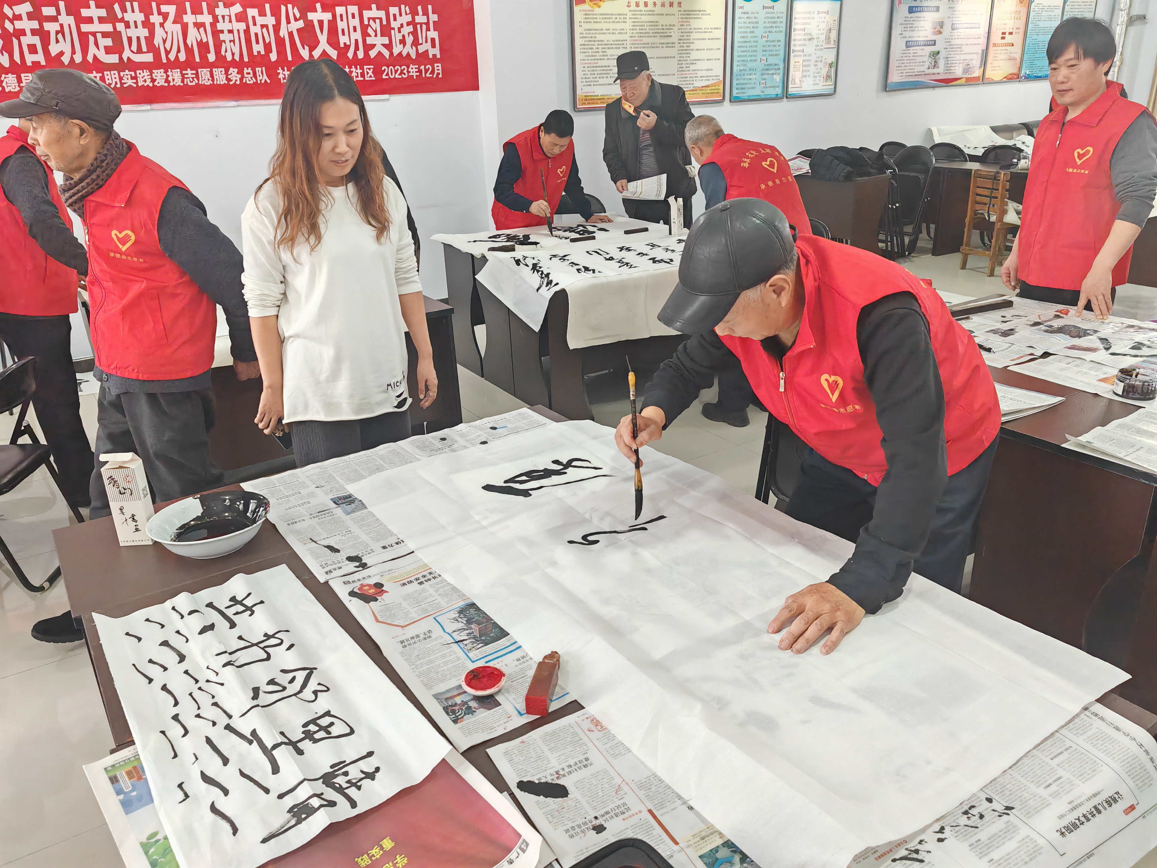 河北承德县：“翰墨有传承 共书邻里情”文明实践活动进社区_fororder_志愿者讲解运笔技巧 摄影 刘峥