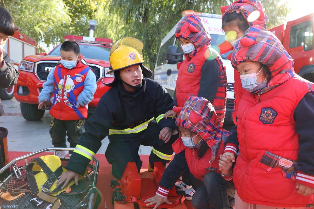保定市满城区消防安全委员会举行2023年消防宣传月启动仪式_fororder_消防队员为幼童介绍有关消防器材 摄影 任政