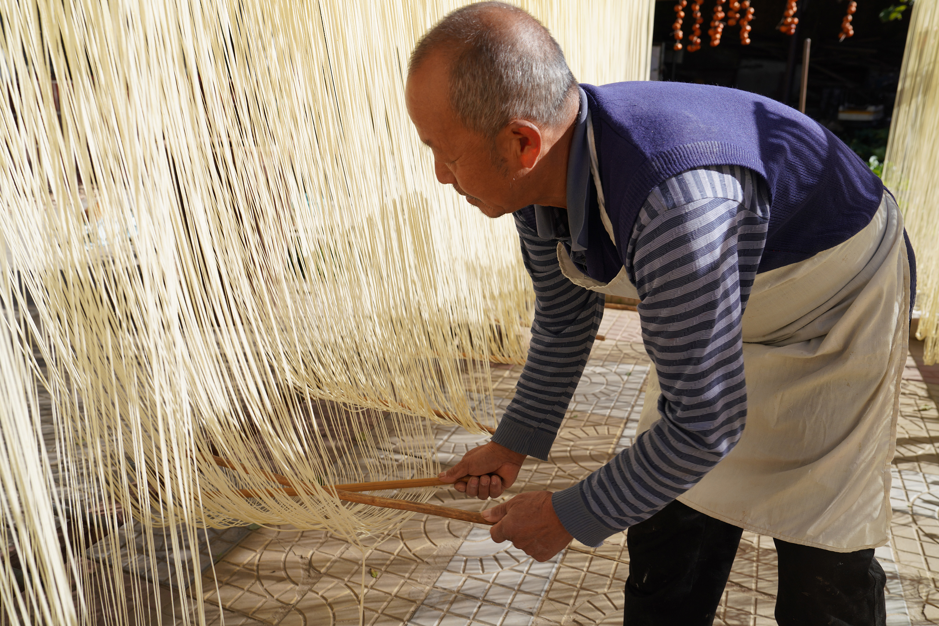 圖片默認標題_fororder_李明雙為晾曬的抻面放置下壓柱。 攝影 王磊