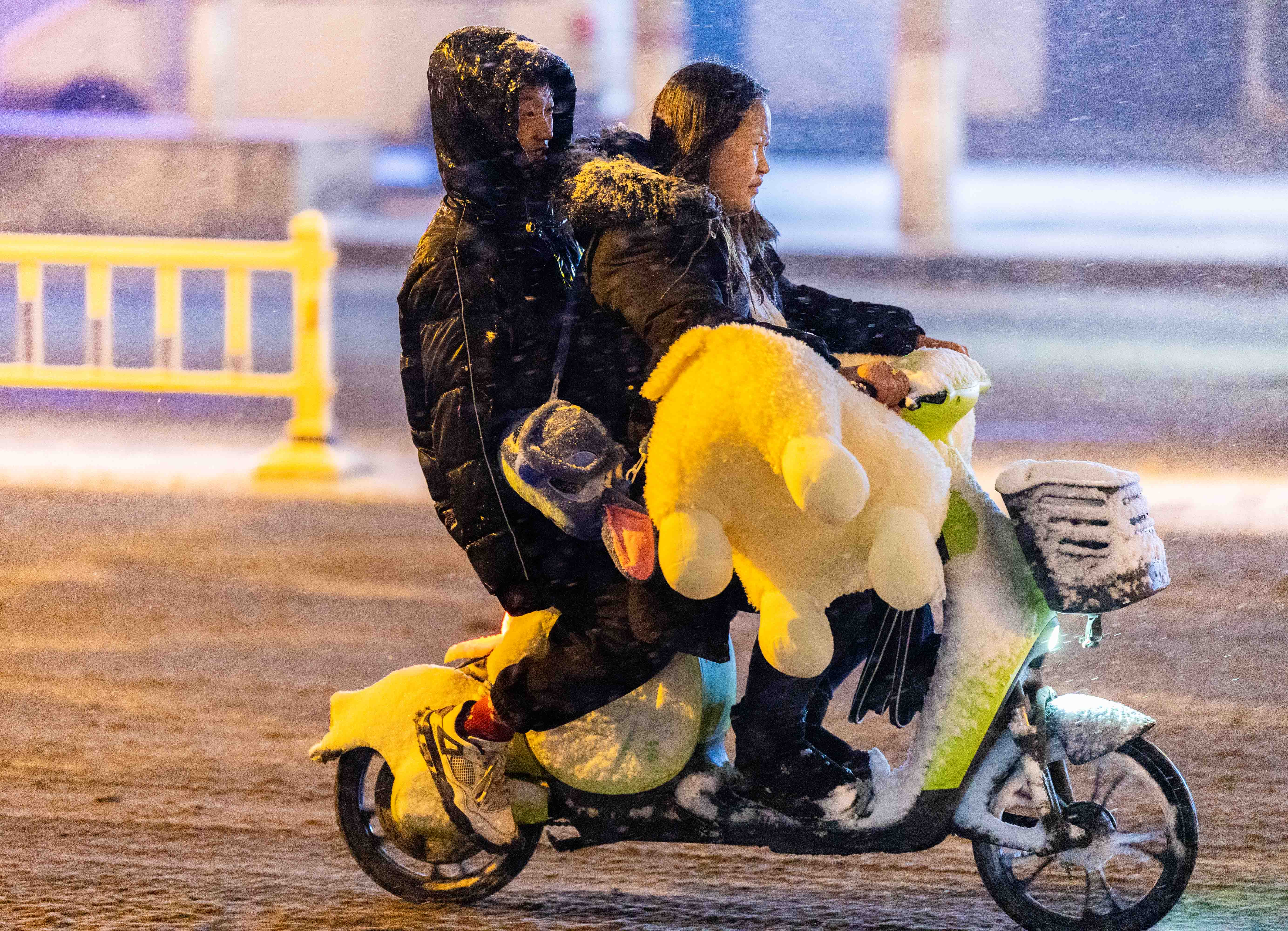 雪落青城景如画_fororder_4——2023年12月10日晚，市民冒雪在呼和浩特市玉泉区街头出行。20231210-EB3A5405