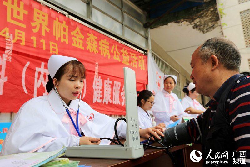 图片默认标题_fororder_4月11日，广西柳州市融安县政府大院，一名南丁格尔志愿者在为老人测量血压.JPG
