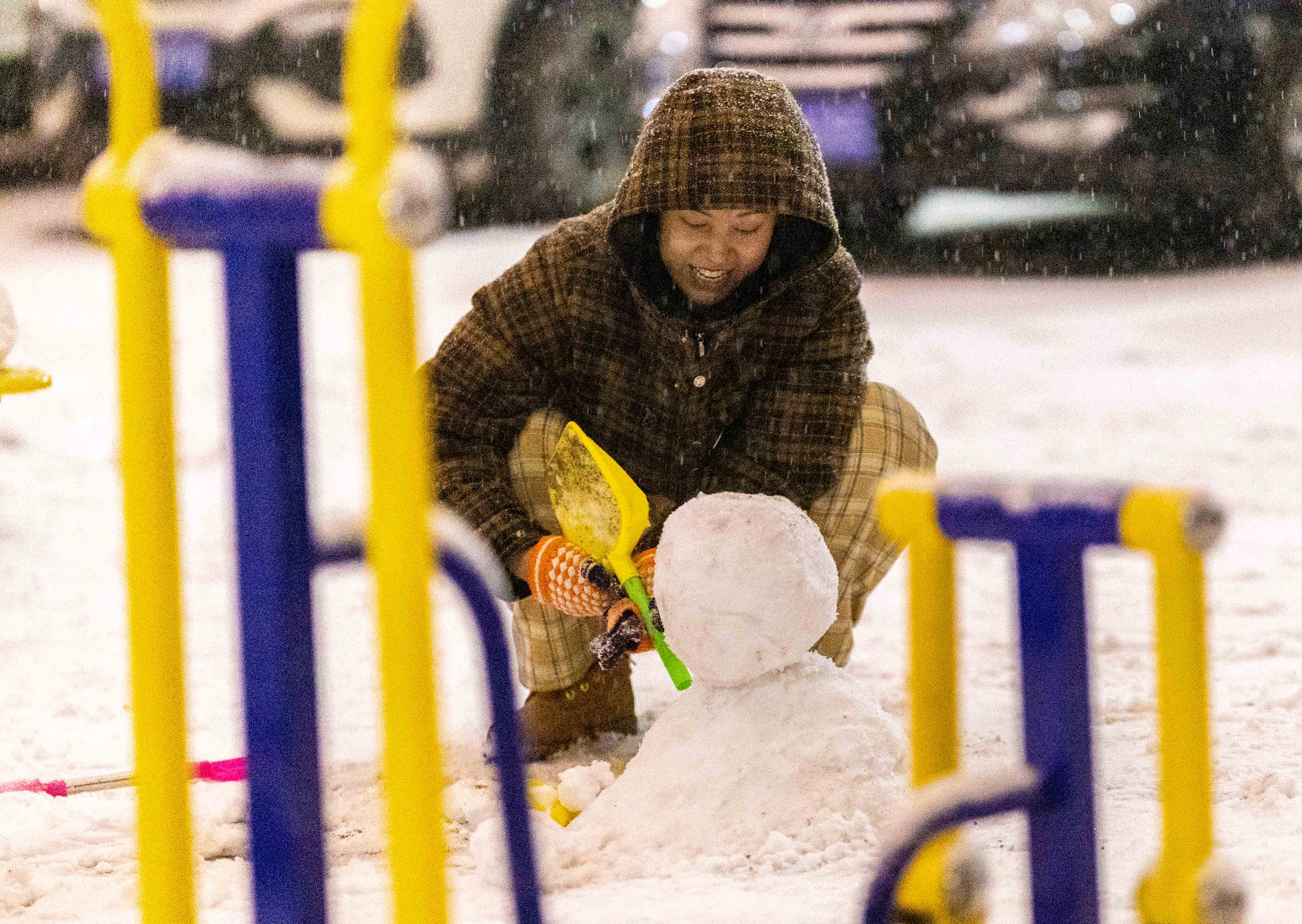 雪落青城景如画_fororder_6——2023年12月10日晚，呼和浩特市玉泉区，市民在雪中堆雪人。20231210-EB3A5737