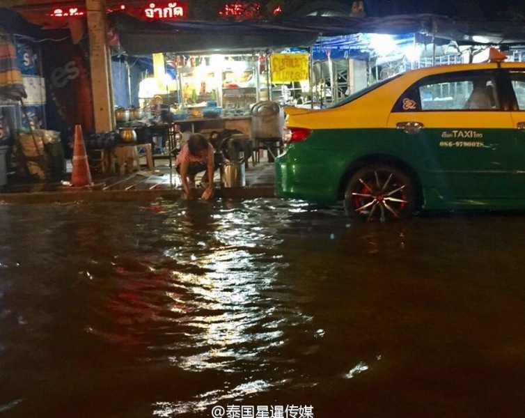 泰国餐馆大妈在地上积水中洗锅碗