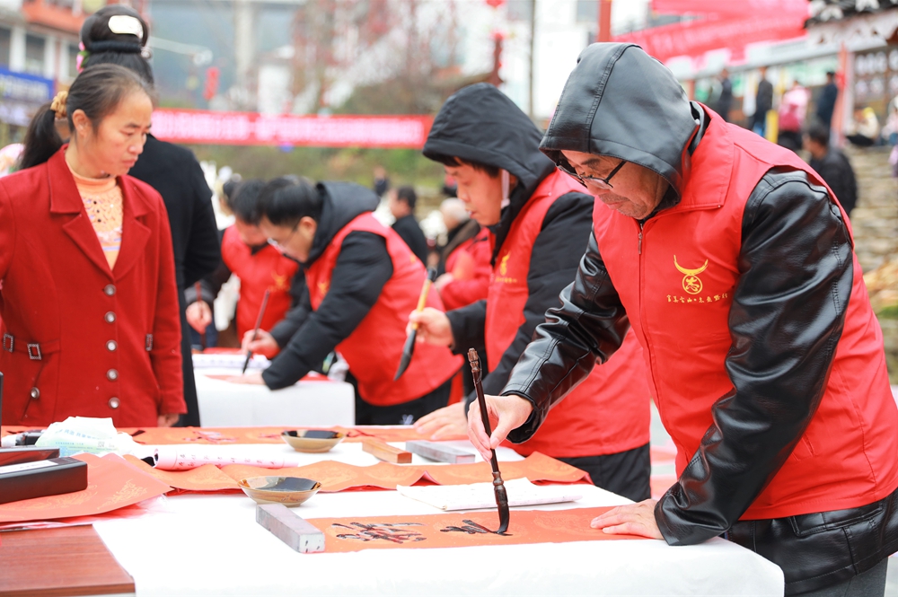 貴州雷山：寫春聯迎新春_fororder_2023年2月2日，在貴州省黔東南苗族侗族自治州雷山縣龍頭街道移民安置點，書法志願者為居民義務寫春聯。 (3)