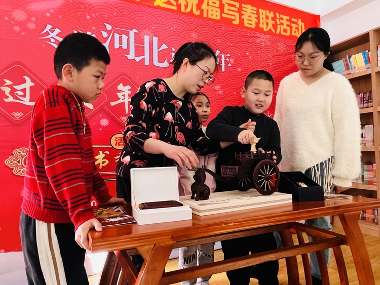 图片默认标题_fororder_图为涞水县图书馆工作人员正在向市民介绍指南车非遗技艺。（徐梓钰 摄）