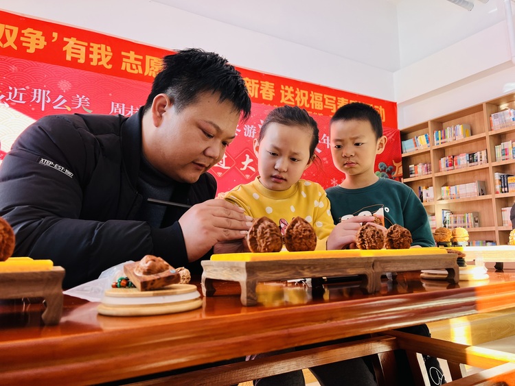 图片默认标题_fororder_图为涞水县图书馆小朋友正在了解核雕非遗技艺。（徐梓钰摄）