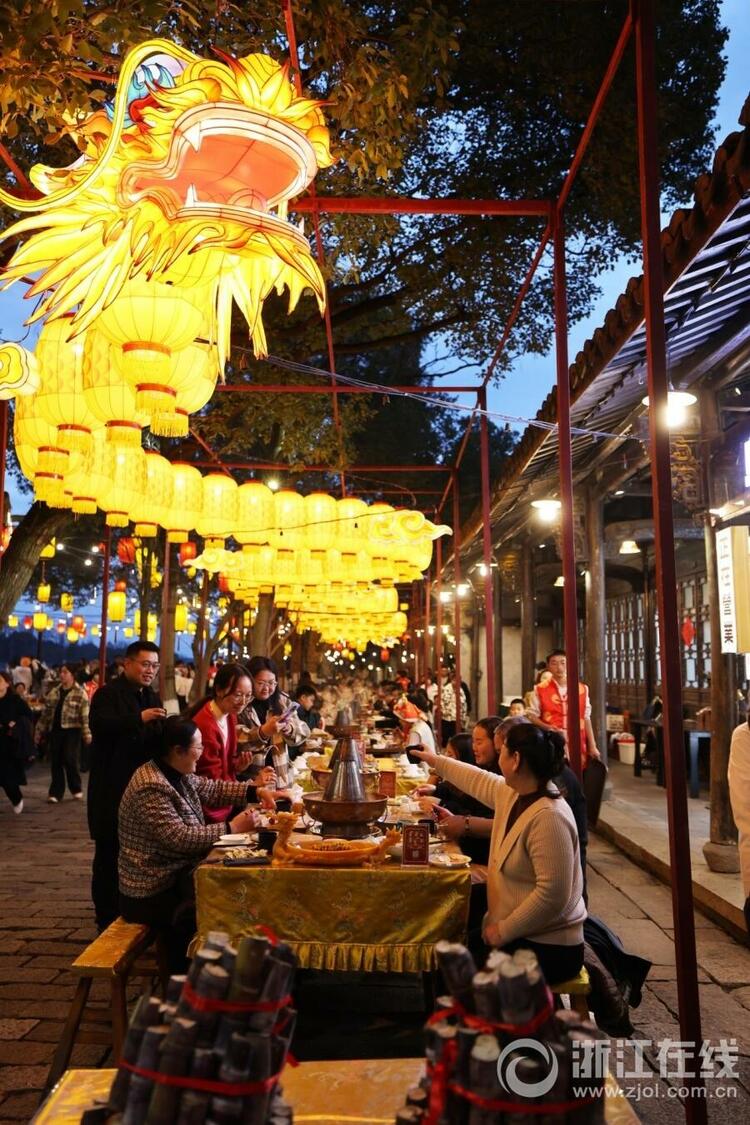 邢然 陆佳钰)2月13日晚,乌镇景区在街巷大摆长街宴,游客边吃着美食,边