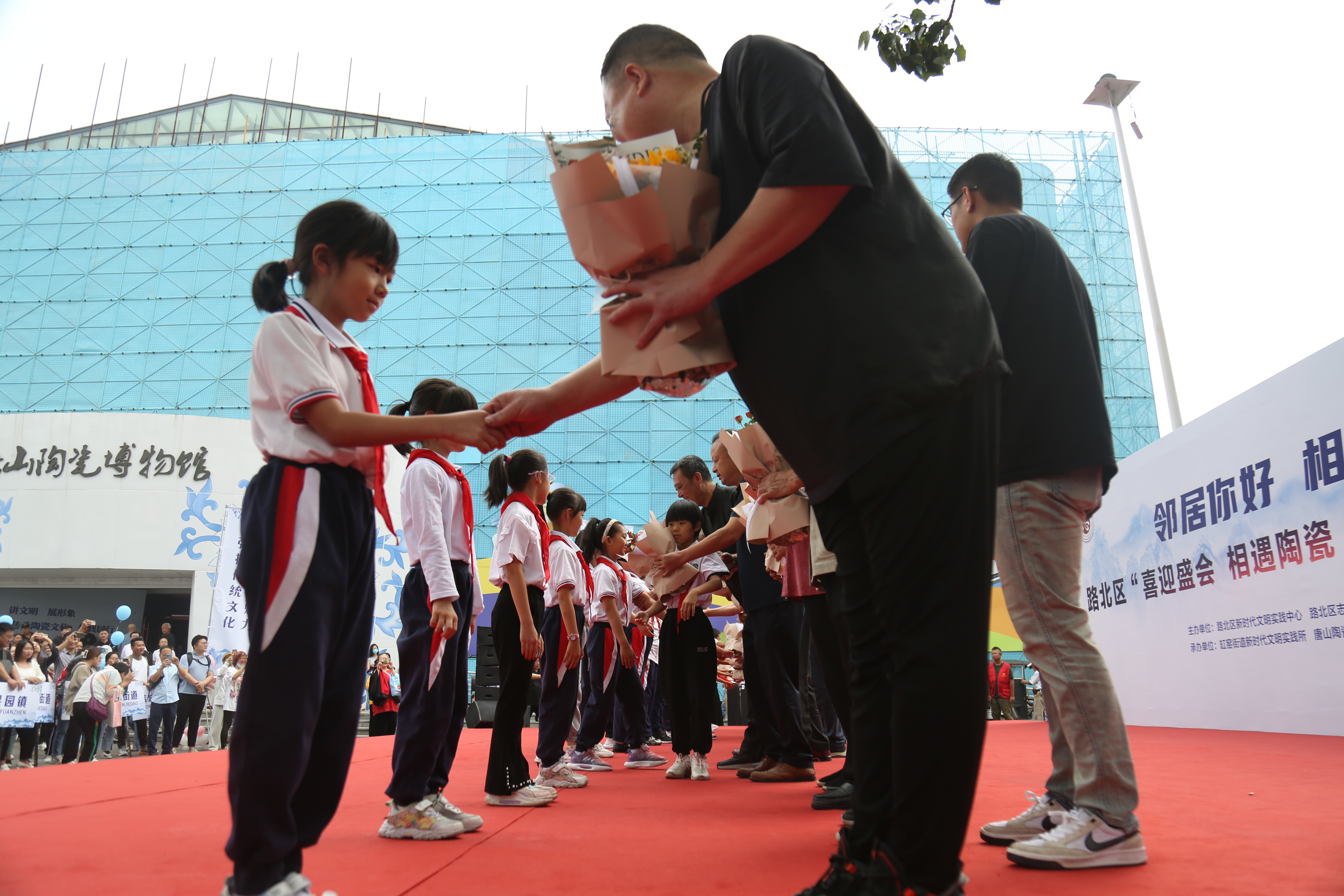 图片默认标题_fororder_路北区邻里节活动现场，少先队员们为陶瓷艺术大师们献上鲜花 马雅雄 摄.JPG
