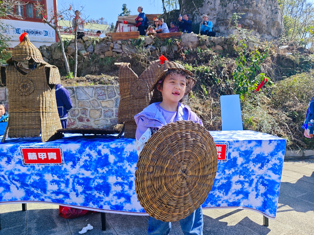 貴州安順：萬人歡度苗族跳花節_fororder_跳花節活動現場，小遊客試穿阿歪寨藤甲  戴勝信 攝