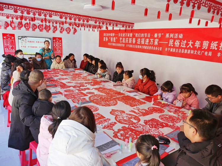 河北丰宁举办“我们的中国梦 文化进万家”亲子非遗研习活动_fororder_县级代表性传承人曹艳玲介绍满族剪纸文化  拍摄白艳宁 (1)