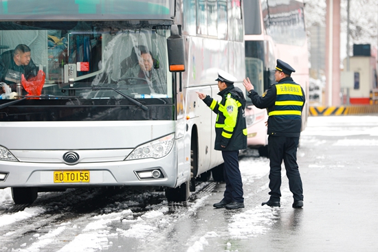 貴州天柱：警車雪中護航 溫暖群眾回家路_fororder_交警在指揮車輛.JPG