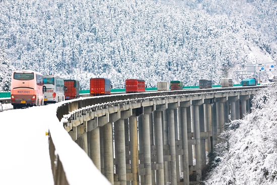 貴州天柱：警車雪中護航 溫暖群眾回家路_fororder_警車壓速帶道，車輛有序跟隨1.JPG