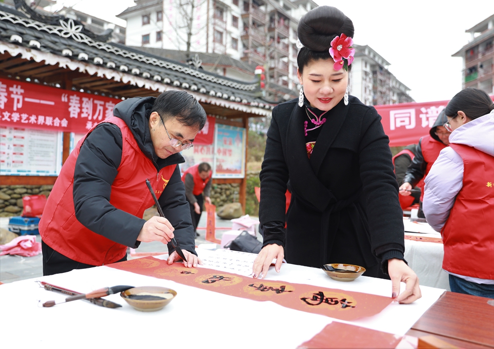 貴州雷山：寫春聯迎新春_fororder_2023年2月2日，在貴州省黔東南苗族侗族自治州雷山縣龍頭街道移民安置點，書法志願者為居民義務寫春聯。 (4)